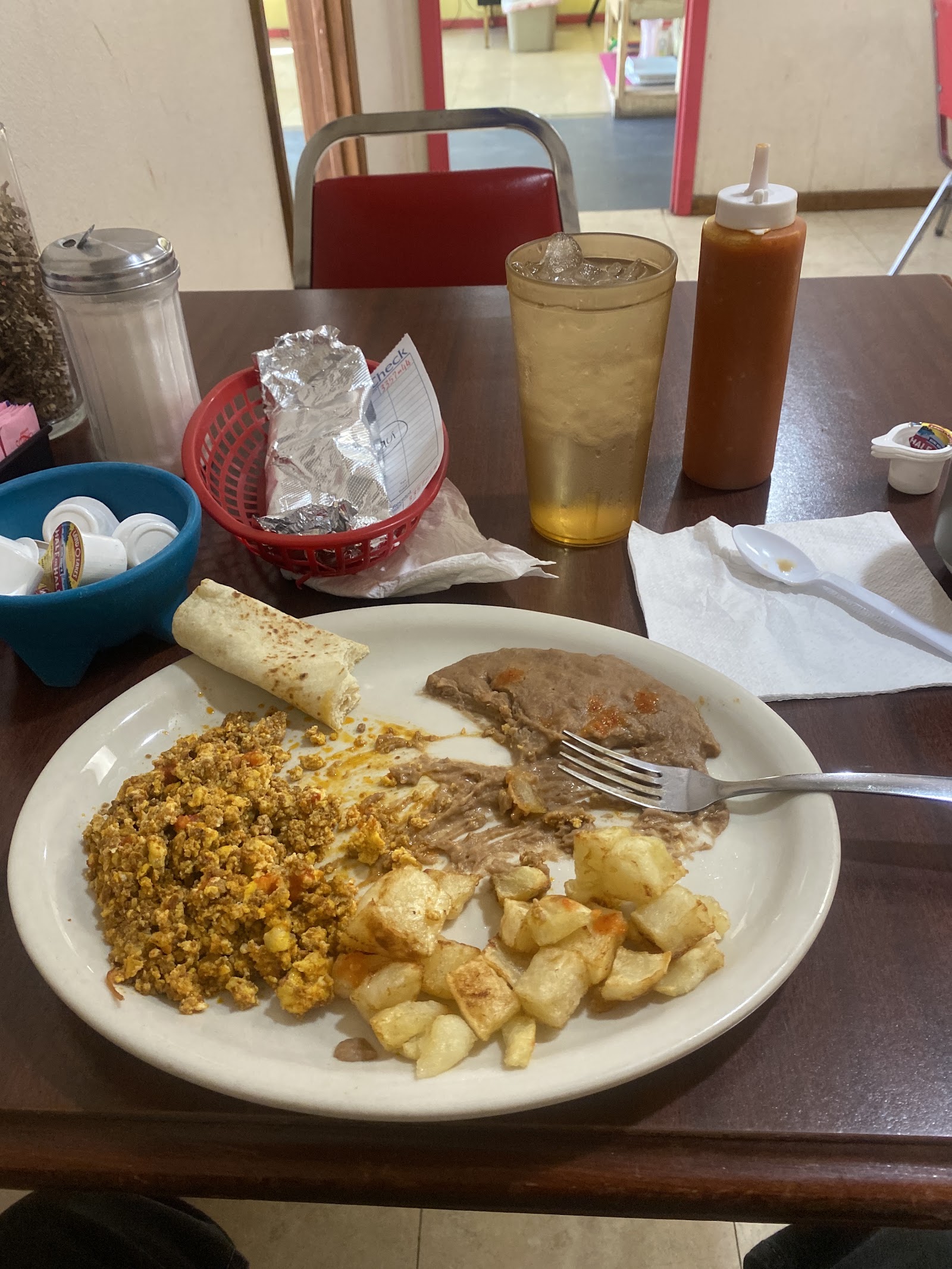 Breakfast plate with taquito, migas, refried beans and potatoes